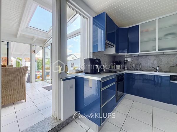 Maison familiale avec véranda, terrasse couverte, jardin et piscine à Village-Neuf

Ici, la surface habitable ne raconte pas tout. 112 m² habitables auxquels s’ajoutent une véranda d’environ 10 m², une terrasse couverte tournée vers le jardin, un sous-sol et un double garage. 

Le charme d’une maison des années 30 dans laquelle on peut se créer une véritable vie dedans-dehors, à deux pas de la frontière bâloise. Et pour les frontaliers, Bâle est accessible à vélo via la piste cyclable longeant le canal de Huningue.

Depuis la rue, on ne soupçonne pas le cadre de vie que cette maison réserve à l’arrière.

Résolument tournée vers l’extérieur, elle s’ouvre sur un jardin intimiste où chaque espace trouve naturellement sa place. Une belle terrasse couverte pour les repas entre amis ou en famille. À moins que vous ne préfériez vous installer au bord de la piscine chauffée … Autour, l’espace paysager invite au repos et à la convivialité.

Une sensation de vacances chez soi, avec un autre avantage appréciable : un jardin aux dimensions raisonnables, pensé pour en profiter sans devenir esclave de son entretien. Un puits présent sur la propriété permet par ailleurs d’assurer l’arrosage du jardin.

À l’intérieur aussi, chaque espace a sa fonction et la circulation est fluide.

Au rez-de-chaussée, le séjour de 32,6 m² invite à se prélasser près du poêle à bois. La cuisine équipée de 12 m² offre un espace confortable pour cuisiner, tandis que la véranda d’environ 10 m² devient naturellement une pièce supplémentaire pour partager les repas, avec le jardin en toile de fond.

Le + de ce rez-de-chaussée ? Une salle d’eau avec WC.

En montant à l’étage, même le palier a été optimisé avec un petit espace buanderie astucieusement dissimulé.

Puis vient l’une des belles surprises de la maison : une vaste mezzanine de plus de 23 m².

Aujourd’hui ouverte, elle sera votre terrain de jeu. Espace télétravail, bibliothèque, salle de jeux pour les enfants, salon télé… à chacun d’imaginer sa façon de l’habiter. Elle pourra également être cloisonnée pour créer une troisième chambre, qui viendra alors compléter les deux chambres existantes de 12,6 et 11,2 m².

La salle de bains de 7,6 m², avec baignoire, double vasque et WC, est quant à elle dimensionnée pour ces matins en famille où l’on apprécie de ne pas se marcher dessus.

Et ce n’est pas tout.

Au sous-sol, on retrouve une partie chaufferie, un atelier ainsi qu’un espace déjà aménagé en salle de sport, à conserver tel quel ou à réinventer selon vos besoins.

À l’extérieur, le double garage, la piscine chauffée et son local technique indépendant complètent les prestations de la maison.

Le tout prend place sur une parcelle de 480 m².

Enfin, sa situation en zone frontalière, avec des accès faciles vers la Suisse comme vers l’Allemagne, est particulièrement adaptée à la vie quotidienne des actifs du secteur.

Une maison avec jardin et piscine, une vraie vie dedans-dehors et Bâle à portée de vélo : profiter pleinement de chez soi sans renoncer à la proximité de la frontière.