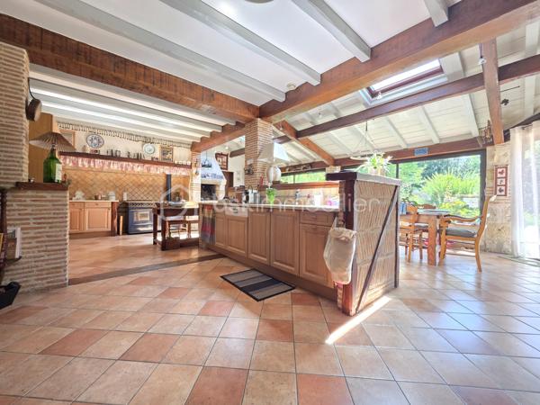 Située sur la commune prisée de Brax, à proximité immédiate du Passage d’Agen, cette belle maison familiale construite en 1994 développe 235 m² habitables sur une magnifique parcelle arborée d’environ 3 000 m².
Dès l’entrée, vous découvrirez un hall accueillant desservant un vaste espace de vie lumineux composé d’une cuisine conviviale ouverte sur 2 espaces séjours chaleureux avec une cheminée pour les moments en famille ou entre amis. 
Une buanderie/cellier attenant à la cuisine complète cet espace fonctionnel.
Le rez-de-chaussée propose également :
un WC indépendant,
une cave en sous-sol,
Une chambre pouvant faire office de bureau,
ainsi qu’un espace nuit comprenant une chambre, une salle de bain et un dressing.

À l’étage, un dégagement dessert :
une agréable mezzanine,
3 chambres supplémentaires,
un WC indépendant,
et une seconde salle de bain.

Côté annexes, la propriété bénéficie d’un double garage ainsi que d’un abri voiture.
À l’extérieur, tout a été pensé pour profiter pleinement des beaux jours : une superbe piscine au chlore de 11 x 5 mètres avec volet immergé, accompagnée de son pool house, offre un cadre de vie privilégié et intimiste.
1 wc exterieur.

Les prestations techniques viennent compléter le confort de cette maison :
Chauffage et production d’eau chaude au gaz de ville,
Cheminée
Huisseries double vitrage,
Volets bois,
Fibre optique,
Arrosage automatique,
Interphone et vidéophone,
Puits,
Assainissement tout-à-l’égout.
Taxe foncière : 2 783 €.
Une maison spacieuse et lumineuse, idéale pour une grande famille recherchant calme, confort et proximité des commodités.