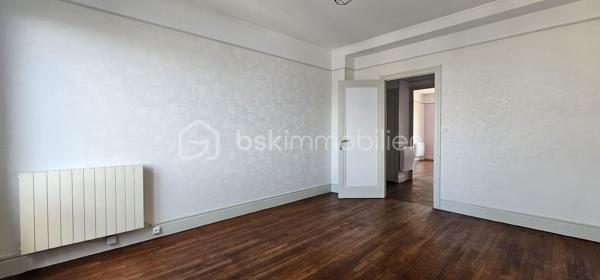 Idéalement situé en plein cœur de Vichy, à proximité immédiate des commerces et de toutes les commodités, découvrez cet agréable appartement traversant de 76,94 m², situé au 5ᵉ étage avec ascenseur d’une résidence des années 1970.

Bénéficiant d’une belle hauteur sous plafond et d’une distribution fonctionnelle, cet appartement offre de beaux volumes et une agréable luminosité.

L’entrée, particulièrement spacieuse, dispose de nombreux rangements et dessert les différentes pièces de l’appartement.

La partie jour se compose d’un séjour d’environ 22 m², ouvrant sur un balcon d’environ 6 m². Cet espace extérieur constitue un véritable atout et offre une vue dégagée sur Vichy et les collines environnantes.

La cuisine, aménagée et équipée, est indépendante et fonctionnelle.

La partie nuit propose deux vastes chambres, situées au calme à l’arrière de la résidence, ainsi qu’une salle d’eau avec douche à l’italienne et des WC indépendants.

Une cave complète ce bien.

L’appartement est en bon état général et ne nécessite pas de travaux importants. Son caractère traversant, ses volumes, sa hauteur sous plafond et sa loggia avec vue dégagée en font un bien particulièrement agréable à vivre.

Difficile de trouver emplacement plus pratique : la résidence se situe à quelques pas du centre commercial des Quatre Chemins, de la rue Georges-Clemenceau, de la rue Wilson et de la rue de Paris.

La gare SNCF se trouve à environ 500 à 600 mètres, tandis que le marché couvert est également accessible à pied en quelques minutes.

Un appartement idéal pour une résidence principale, un pied-à-terre ou un investissement locatif, permettant de profiter pleinement de la vie du centre-ville de Vichy tout en bénéficiant d’un étage élevé, d’un ascenseur, d’une vue dégagée et d’un espace extérieur.

Un bien complet, central et fonctionnel, à découvrir sans tarder.