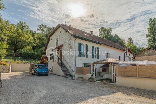 Sur la commune de Seyssel, à moins de 2 kilomètres du centre-ville et de toutes les commodités, venez découvrir cette jolie maison mitoyenne sans vis à vis de 136 m², bénéficiant d’un environnement agréable et d’un vaste terrain arboré de 2 792 m².

La maison se compose d’une cuisine ouverte sur le séjour avec accès direct à une première grande terrasse. Une suite parentale complète ce niveau avec chambre, salle d’eau, WC et accès à une seconde terrasse indépendante.

À l’étage, vous découvrirez un grand salon, trois chambres ainsi qu’une salle de bains avec WC. Les combles, déjà accessibles par un escalier, offrent un potentiel d’aménagement supplémentaire.

L’extérieur constitue un véritable atout de cette propriété. Le grand terrain, arboré et soigneusement entretenu, offre de nombreuses possibilités d’aménagement selon vos envies. Vous profiterez d’un espace potager/jardin, de deux terrasses extérieures, d’un grand espace de stationnement ainsi que d’un portail permettant de sécuriser l’accès à la propriété.

Le jardin bénéficie également d’une belle vue sur le Grand Colombier, apportant un cadre particulièrement agréable aux espaces extérieurs. Un atelier vient compléter l’ensemble.

Une maison pleine de charme, à découvrir sans tarder.