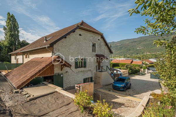Sur la commune de Seyssel, à moins de 2 kilomètres du centre-ville et de toutes les commodités, venez découvrir cette jolie maison mitoyenne sans vis à vis de 136 m², bénéficiant d’un environnement agréable et d’un vaste terrain arboré de 2 792 m².

La maison se compose d’une cuisine ouverte sur le séjour avec accès direct à une première grande terrasse. Une suite parentale complète ce niveau avec chambre, salle d’eau, WC et accès à une seconde terrasse indépendante.

À l’étage, vous découvrirez un grand salon, trois chambres ainsi qu’une salle de bains avec WC. Les combles, déjà accessibles par un escalier, offrent un potentiel d’aménagement supplémentaire.

L’extérieur constitue un véritable atout de cette propriété. Le grand terrain, arboré et soigneusement entretenu, offre de nombreuses possibilités d’aménagement selon vos envies. Vous profiterez d’un espace potager/jardin, de deux terrasses extérieures, d’un grand espace de stationnement ainsi que d’un portail permettant de sécuriser l’accès à la propriété.

Le jardin bénéficie également d’une belle vue sur le Grand Colombier, apportant un cadre particulièrement agréable aux espaces extérieurs. Un atelier vient compléter l’ensemble.

Une maison pleine de charme, à découvrir sans tarder.