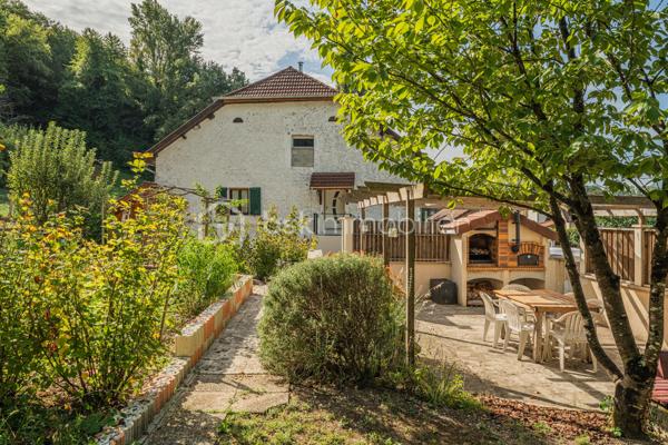 Sur la commune de Seyssel, à moins de 2 kilomètres du centre-ville et de toutes les commodités, venez découvrir cette jolie maison mitoyenne sans vis à vis de 136 m², bénéficiant d’un environnement agréable et d’un vaste terrain arboré de 2 792 m².

La maison se compose d’une cuisine ouverte sur le séjour avec accès direct à une première grande terrasse. Une suite parentale complète ce niveau avec chambre, salle d’eau, WC et accès à une seconde terrasse indépendante.

À l’étage, vous découvrirez un grand salon, trois chambres ainsi qu’une salle de bains avec WC. Les combles, déjà accessibles par un escalier, offrent un potentiel d’aménagement supplémentaire.

L’extérieur constitue un véritable atout de cette propriété. Le grand terrain, arboré et soigneusement entretenu, offre de nombreuses possibilités d’aménagement selon vos envies. Vous profiterez d’un espace potager/jardin, de deux terrasses extérieures, d’un grand espace de stationnement ainsi que d’un portail permettant de sécuriser l’accès à la propriété.

Le jardin bénéficie également d’une belle vue sur le Grand Colombier, apportant un cadre particulièrement agréable aux espaces extérieurs. Un atelier vient compléter l’ensemble.

Une maison pleine de charme, à découvrir sans tarder.