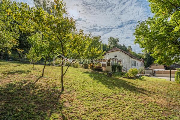 Sur la commune de Seyssel, à moins de 2 kilomètres du centre-ville et de toutes les commodités, venez découvrir cette jolie maison mitoyenne sans vis à vis de 136 m², bénéficiant d’un environnement agréable et d’un vaste terrain arboré de 2 792 m².

La maison se compose d’une cuisine ouverte sur le séjour avec accès direct à une première grande terrasse. Une suite parentale complète ce niveau avec chambre, salle d’eau, WC et accès à une seconde terrasse indépendante.

À l’étage, vous découvrirez un grand salon, trois chambres ainsi qu’une salle de bains avec WC. Les combles, déjà accessibles par un escalier, offrent un potentiel d’aménagement supplémentaire.

L’extérieur constitue un véritable atout de cette propriété. Le grand terrain, arboré et soigneusement entretenu, offre de nombreuses possibilités d’aménagement selon vos envies. Vous profiterez d’un espace potager/jardin, de deux terrasses extérieures, d’un grand espace de stationnement ainsi que d’un portail permettant de sécuriser l’accès à la propriété.

Le jardin bénéficie également d’une belle vue sur le Grand Colombier, apportant un cadre particulièrement agréable aux espaces extérieurs. Un atelier vient compléter l’ensemble.

Une maison pleine de charme, à découvrir sans tarder.