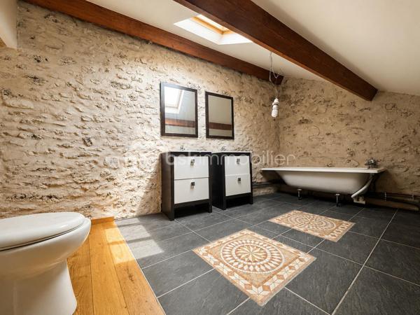 Maison de ville en pierre de 135 m² – Charme de l'ancien et fort potentiel d'aménagement

Laissez-vous séduire par cette authentique maison de ville en pierre de 135 m², pleine de caractère et offrant un très beau potentiel d'évolution.

Dès l'entrée, vous découvrirez une véritable entrée indépendante desservant une cuisine aménagée avec accès à une terrasse intimiste, entièrement à l'abri des regards. Cet espace extérieur offre de nombreuses possibilités d'aménagement pour créer un véritable lieu de vie convivial.

Le rez-de-chaussée comprend également un spacieux salon, une chambre, une salle d'eau ainsi qu'un WC indépendant.

À l'étage, une magnifique pièce d'environ 35 m² laisse libre cours à vos projets : création d'une ou plusieurs chambres, d'un bureau, d'une salle de jeux ou encore d'un espace détente. Elle dessert une suite parentale, offrant une belle modularité selon vos besoins et vos envies.

Avec le charme de la pierre, ses beaux volumes et son important potentiel d'aménagement, cette maison représente une belle opportunité pour les acquéreurs souhaitant créer un intérieur à leur image.