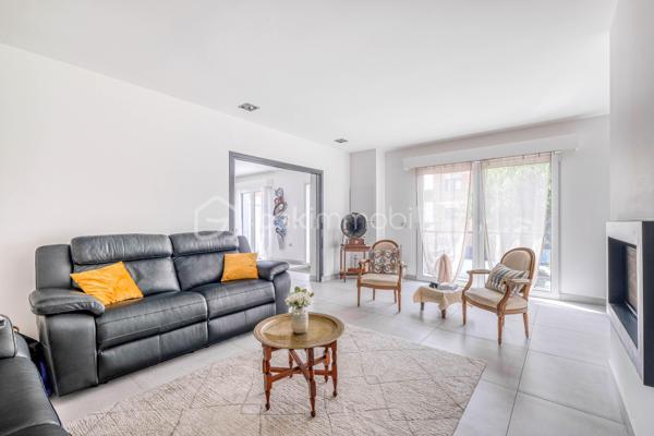Élevée et baignée de lumière, cette maison de 124 m² de surface habitable, offrant 175 m² de surface utile au total avec buanderie et garage, récente offre une vraie vie de famille chic et pratique, à deux pas des commodités de Champigny.

Les atouts qui font la différence

Entrée majestueuse: on gravit quelques marches et l’on découvre un grand séjour traversant, chaleureux, ouvert sur la terrasse surélevée – parfait pour recevoir.
Cuisine esprit « family room »: moderne, entièrement équipée, conviviale autour de la table centrale.
Salon cocooning avec cheminée: belles soirées assurées hiver comme été.

Rez‑de‑jardin polyvalent

- Chambre indépendante parfaite pour télétravail, ado ou invités.
- Couloir avec rangements intégrés très pratiques.
-  Salle d’eau avec douche et WC.
- Buanderie attenante.
- Grand garage motorisé + portail électrique, borne de recharge pour véhicule électrique.

Étage nuit

- Deux chambres confortables avec rangements, traversantes, équipées de Velux et volets roulants électriques pour une lumière maîtrisée et un confort optimal.
- Spacieuse salle de bains: baignoire, douche, double vasque.
- WC séparés.

Confort et équipements

- Jardin paysager, impeccablement entretenu, sans vis‑à‑vis: véritable prolongement du séjour pour des réceptions élégantes.
 - Espace latéral prêt à vivre (eau + électricité): parfait pour imaginer une cuisine d’été raffinée, un jacuzzi ou un lounge extérieur.
- Fermetures premium: volets roulants électriques sur baies et Velux, double vitrage performant, éclairages encastrés.
- Stationnement d’exception: double garage fermé avec porte motorisée, portail d’entrée électrique pour un accès fluide et sécurisé.
- Mobilité de demain: borne de recharge pour véhicule électrique intégrée.
- Praticité quotidienne: buanderie dédiée, rangements généreux, matériaux choisis pour leur durabilité et leur facilité d’entretien.
- Chauffage performant: chaudière gaz à condensation Frisquet avec plancher chauffant, complétée par un insert bois pour l’appoint; production d’eau chaude couplée à la chaudière.

 Dans un secteur résidentiel recherché, cette maison clé en main marie style, confort et prestations haut de gamme, dedans comme dehors. 
Dossier complet (plans, surfaces, diagnostics) et visites privées sur rendez‑vous. Un bien rare, à découvrir sans tarder.