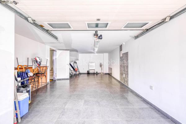 Élevée et baignée de lumière, cette maison de 124 m² de surface habitable, offrant 175 m² de surface utile au total avec buanderie et garage, récente offre une vraie vie de famille chic et pratique, à deux pas des commodités de Champigny.

Les atouts qui font la différence

Entrée majestueuse: on gravit quelques marches et l’on découvre un grand séjour traversant, chaleureux, ouvert sur la terrasse surélevée – parfait pour recevoir.
Cuisine esprit « family room »: moderne, entièrement équipée, conviviale autour de la table centrale.
Salon cocooning avec cheminée: belles soirées assurées hiver comme été.

Rez‑de‑jardin polyvalent

- Chambre indépendante parfaite pour télétravail, ado ou invités.
- Couloir avec rangements intégrés très pratiques.
-  Salle d’eau avec douche et WC.
- Buanderie attenante.
- Grand garage motorisé + portail électrique, borne de recharge pour véhicule électrique.

Étage nuit

- Deux chambres confortables avec rangements, traversantes, équipées de Velux et volets roulants électriques pour une lumière maîtrisée et un confort optimal.
- Spacieuse salle de bains: baignoire, douche, double vasque.
- WC séparés.

Confort et équipements

- Jardin paysager, impeccablement entretenu, sans vis‑à‑vis: véritable prolongement du séjour pour des réceptions élégantes.
 - Espace latéral prêt à vivre (eau + électricité): parfait pour imaginer une cuisine d’été raffinée, un jacuzzi ou un lounge extérieur.
- Fermetures premium: volets roulants électriques sur baies et Velux, double vitrage performant, éclairages encastrés.
- Stationnement d’exception: double garage fermé avec porte motorisée, portail d’entrée électrique pour un accès fluide et sécurisé.
- Mobilité de demain: borne de recharge pour véhicule électrique intégrée.
- Praticité quotidienne: buanderie dédiée, rangements généreux, matériaux choisis pour leur durabilité et leur facilité d’entretien.
- Chauffage performant: chaudière gaz à condensation Frisquet avec plancher chauffant, complétée par un insert bois pour l’appoint; production d’eau chaude couplée à la chaudière.

 Dans un secteur résidentiel recherché, cette maison clé en main marie style, confort et prestations haut de gamme, dedans comme dehors. 
Dossier complet (plans, surfaces, diagnostics) et visites privées sur rendez‑vous. Un bien rare, à découvrir sans tarder.