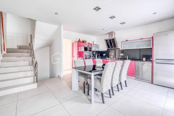 Élevée et baignée de lumière, cette maison de 124 m² de surface habitable, offrant 175 m² de surface utile au total avec buanderie et garage, récente offre une vraie vie de famille chic et pratique, à deux pas des commodités de Champigny.

Les atouts qui font la différence

Entrée majestueuse: on gravit quelques marches et l’on découvre un grand séjour traversant, chaleureux, ouvert sur la terrasse surélevée – parfait pour recevoir.
Cuisine esprit « family room »: moderne, entièrement équipée, conviviale autour de la table centrale.
Salon cocooning avec cheminée: belles soirées assurées hiver comme été.

Rez‑de‑jardin polyvalent

- Chambre indépendante parfaite pour télétravail, ado ou invités.
- Couloir avec rangements intégrés très pratiques.
-  Salle d’eau avec douche et WC.
- Buanderie attenante.
- Grand garage motorisé + portail électrique, borne de recharge pour véhicule électrique.

Étage nuit

- Deux chambres confortables avec rangements, traversantes, équipées de Velux et volets roulants électriques pour une lumière maîtrisée et un confort optimal.
- Spacieuse salle de bains: baignoire, douche, double vasque.
- WC séparés.

Confort et équipements

- Jardin paysager, impeccablement entretenu, sans vis‑à‑vis: véritable prolongement du séjour pour des réceptions élégantes.
 - Espace latéral prêt à vivre (eau + électricité): parfait pour imaginer une cuisine d’été raffinée, un jacuzzi ou un lounge extérieur.
- Fermetures premium: volets roulants électriques sur baies et Velux, double vitrage performant, éclairages encastrés.
- Stationnement d’exception: double garage fermé avec porte motorisée, portail d’entrée électrique pour un accès fluide et sécurisé.
- Mobilité de demain: borne de recharge pour véhicule électrique intégrée.
- Praticité quotidienne: buanderie dédiée, rangements généreux, matériaux choisis pour leur durabilité et leur facilité d’entretien.
- Chauffage performant: chaudière gaz à condensation Frisquet avec plancher chauffant, complétée par un insert bois pour l’appoint; production d’eau chaude couplée à la chaudière.

 Dans un secteur résidentiel recherché, cette maison clé en main marie style, confort et prestations haut de gamme, dedans comme dehors. 
Dossier complet (plans, surfaces, diagnostics) et visites privées sur rendez‑vous. Un bien rare, à découvrir sans tarder.