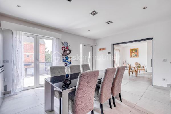 Élevée et baignée de lumière, cette maison de 124 m² de surface habitable, offrant 175 m² de surface utile au total avec buanderie et garage, récente offre une vraie vie de famille chic et pratique, à deux pas des commodités de Champigny.

Les atouts qui font la différence

Entrée majestueuse: on gravit quelques marches et l’on découvre un grand séjour traversant, chaleureux, ouvert sur la terrasse surélevée – parfait pour recevoir.
Cuisine esprit « family room »: moderne, entièrement équipée, conviviale autour de la table centrale.
Salon cocooning avec cheminée: belles soirées assurées hiver comme été.

Rez‑de‑jardin polyvalent

- Chambre indépendante parfaite pour télétravail, ado ou invités.
- Couloir avec rangements intégrés très pratiques.
-  Salle d’eau avec douche et WC.
- Buanderie attenante.
- Grand garage motorisé + portail électrique, borne de recharge pour véhicule électrique.

Étage nuit

- Deux chambres confortables avec rangements, traversantes, équipées de Velux et volets roulants électriques pour une lumière maîtrisée et un confort optimal.
- Spacieuse salle de bains: baignoire, douche, double vasque.
- WC séparés.

Confort et équipements

- Jardin paysager, impeccablement entretenu, sans vis‑à‑vis: véritable prolongement du séjour pour des réceptions élégantes.
 - Espace latéral prêt à vivre (eau + électricité): parfait pour imaginer une cuisine d’été raffinée, un jacuzzi ou un lounge extérieur.
- Fermetures premium: volets roulants électriques sur baies et Velux, double vitrage performant, éclairages encastrés.
- Stationnement d’exception: double garage fermé avec porte motorisée, portail d’entrée électrique pour un accès fluide et sécurisé.
- Mobilité de demain: borne de recharge pour véhicule électrique intégrée.
- Praticité quotidienne: buanderie dédiée, rangements généreux, matériaux choisis pour leur durabilité et leur facilité d’entretien.
- Chauffage performant: chaudière gaz à condensation Frisquet avec plancher chauffant, complétée par un insert bois pour l’appoint; production d’eau chaude couplée à la chaudière.

 Dans un secteur résidentiel recherché, cette maison clé en main marie style, confort et prestations haut de gamme, dedans comme dehors. 
Dossier complet (plans, surfaces, diagnostics) et visites privées sur rendez‑vous. Un bien rare, à découvrir sans tarder.
