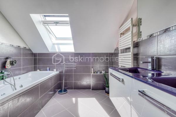 Élevée et baignée de lumière, cette maison de 124 m² de surface habitable, offrant 175 m² de surface utile au total avec buanderie et garage, récente offre une vraie vie de famille chic et pratique, à deux pas des commodités de Champigny.

Les atouts qui font la différence

Entrée majestueuse: on gravit quelques marches et l’on découvre un grand séjour traversant, chaleureux, ouvert sur la terrasse surélevée – parfait pour recevoir.
Cuisine esprit « family room »: moderne, entièrement équipée, conviviale autour de la table centrale.
Salon cocooning avec cheminée: belles soirées assurées hiver comme été.

Rez‑de‑jardin polyvalent

- Chambre indépendante parfaite pour télétravail, ado ou invités.
- Couloir avec rangements intégrés très pratiques.
-  Salle d’eau avec douche et WC.
- Buanderie attenante.
- Grand garage motorisé + portail électrique, borne de recharge pour véhicule électrique.

Étage nuit

- Deux chambres confortables avec rangements, traversantes, équipées de Velux et volets roulants électriques pour une lumière maîtrisée et un confort optimal.
- Spacieuse salle de bains: baignoire, douche, double vasque.
- WC séparés.

Confort et équipements

- Jardin paysager, impeccablement entretenu, sans vis‑à‑vis: véritable prolongement du séjour pour des réceptions élégantes.
 - Espace latéral prêt à vivre (eau + électricité): parfait pour imaginer une cuisine d’été raffinée, un jacuzzi ou un lounge extérieur.
- Fermetures premium: volets roulants électriques sur baies et Velux, double vitrage performant, éclairages encastrés.
- Stationnement d’exception: double garage fermé avec porte motorisée, portail d’entrée électrique pour un accès fluide et sécurisé.
- Mobilité de demain: borne de recharge pour véhicule électrique intégrée.
- Praticité quotidienne: buanderie dédiée, rangements généreux, matériaux choisis pour leur durabilité et leur facilité d’entretien.
- Chauffage performant: chaudière gaz à condensation Frisquet avec plancher chauffant, complétée par un insert bois pour l’appoint; production d’eau chaude couplée à la chaudière.

 Dans un secteur résidentiel recherché, cette maison clé en main marie style, confort et prestations haut de gamme, dedans comme dehors. 
Dossier complet (plans, surfaces, diagnostics) et visites privées sur rendez‑vous. Un bien rare, à découvrir sans tarder.