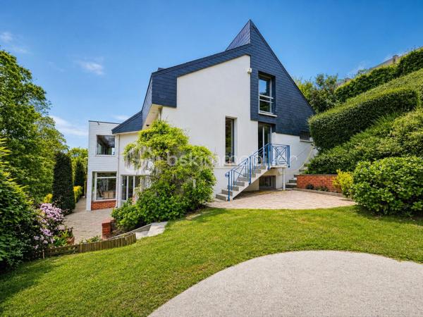 Nichée dans le quartier des Bulins à MONT-SAINT-AIGNAN, cette remarquable demeure familiale de 255m², au cœur d'un magnifique terrain arboré de 1650 m², vous séduira dès les premiers instants.

Alliant espace, confort, tranquillité, ainsi qu'une vue dominante sur Rouen, vous bénéficierez d'un cadre de vie exceptionnel.

Vous découvrirez au rez-de-chaussée une vaste pièce de vie, agrémentée d'une cheminée, ouverte sur une grande terrasse avec une vue panoramique sur Rouen.
Cette maison d'architecte dispose de 5 chambres, 3 salles d'eau, une cuisine équipée et une arrière-cuisine, plusieurs espaces de vie et de travail. 
Elle dispose également d'un rez-de-jardin avec une seconde cuisine et des espaces complémentaires, une piscine chauffée, un garage.

Cette propriété de caractère offre de multiples possibilités d'aménagement et répond parfaitement aux attentes d'une grande famille recherchant un lieu privilégié aux portes de ROUEN.