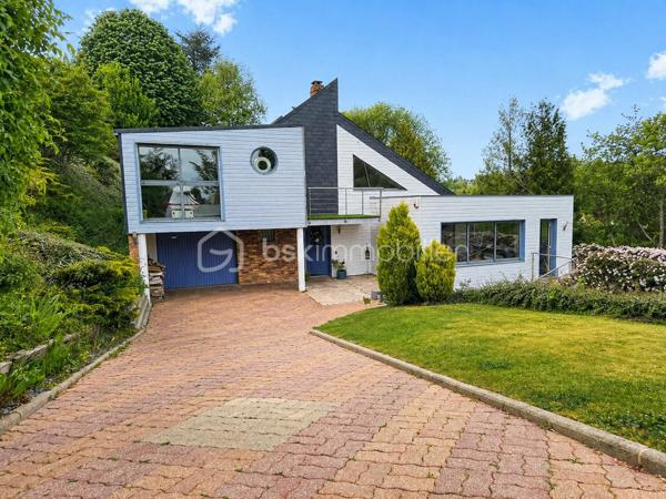 Nichée dans le quartier des Bulins à MONT-SAINT-AIGNAN, cette remarquable demeure familiale de 255m², au cœur d'un magnifique terrain arboré de 1650 m², vous séduira dès les premiers instants.

Alliant espace, confort, tranquillité, ainsi qu'une vue dominante sur Rouen, vous bénéficierez d'un cadre de vie exceptionnel.

Vous découvrirez au rez-de-chaussée une vaste pièce de vie, agrémentée d'une cheminée, ouverte sur une grande terrasse avec une vue panoramique sur Rouen.
Cette maison d'architecte dispose de 5 chambres, 3 salles d'eau, une cuisine équipée et une arrière-cuisine, plusieurs espaces de vie et de travail. 
Elle dispose également d'un rez-de-jardin avec une seconde cuisine et des espaces complémentaires, une piscine chauffée, un garage.

Cette propriété de caractère offre de multiples possibilités d'aménagement et répond parfaitement aux attentes d'une grande famille recherchant un lieu privilégié aux portes de ROUEN.