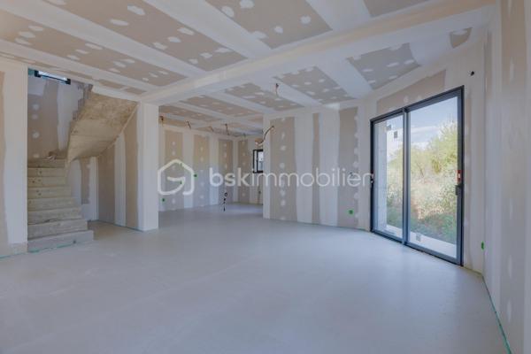 Découvrez cette magnifique maison mitoyenne contemporaine, idéalement située dans une impasse, dans un environnement résidentiel calme et recherché.

Actuellement en cours d'achèvement, cette maison offre une opportunité rare d'emménager dès cet automne dans un bien neuf aux prestations haut de gamme.

Répartie sur un rez-de-chaussée et un étage, elle propose 123 m² habitables, conçus pour offrir un cadre de vie aussi élégant que fonctionnel. Son agencement, imaginé par un architecte d'intérieur, met l'accent sur la luminosité, les volumes et le confort au quotidien.
Vous découvrirez une grande pièce de vie aux lignes arrondies, véritable signature architecturale de la maison. Cet espace lumineux offre de nombreuses possibilités d'aménagement et permet de créer un intérieur unique.

La maison comprend 3 chambres, dont une belle suite parentale avec dressing et salle d'eau privative, et un espace bureau. Les grandes baies vitrées et la hauteur sous plafond supérieure à 2,70 m renforcent la sensation d'espace et baignent les pièces de lumière naturelle.
Implantée sur un terrain avec entrée privative, elle dispose également d'un garage, d'une terrasse ainsi que d'un balcon à l'étage. Les extérieurs, sans vis-à-vis, offrent un cadre de vie intime et agréable.

Les prestations ont été soigneusement sélectionnées pour répondre aux attentes, la maison sera livrée avec :
Carrelage grand format 120 × 120 cm.
Chauffage au sol.
Climatisation réversible.
Grandes baies vitrées.
Finitions haut de gamme.
Matériaux de qualité.

Vous aurez également la possibilité de personnaliser votre cuisine, afin de créer un intérieur entièrement à votre image.

Une maison contemporaine aux prestations premium, alliant design, confort et qualité de construction, idéale pour celles et ceux qui recherchent un bien neuf dans un environnement paisible.

Contactez-nous dès aujourd'hui pour obtenir davantage d'informations et découvrir cette future maison.