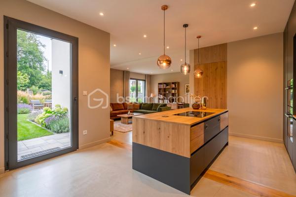 Découvrez cette magnifique maison mitoyenne contemporaine, idéalement située dans une impasse, dans un environnement résidentiel calme et recherché.

Actuellement en cours d'achèvement, cette maison offre une opportunité rare d'emménager dès cet automne dans un bien neuf aux prestations haut de gamme.

Répartie sur un rez-de-chaussée et un étage, elle propose 123 m² habitables, conçus pour offrir un cadre de vie aussi élégant que fonctionnel. Son agencement, imaginé par un architecte d'intérieur, met l'accent sur la luminosité, les volumes et le confort au quotidien.
Vous découvrirez une grande pièce de vie aux lignes arrondies, véritable signature architecturale de la maison. Cet espace lumineux offre de nombreuses possibilités d'aménagement et permet de créer un intérieur unique.

La maison comprend 3 chambres, dont une belle suite parentale avec dressing et salle d'eau privative, et un espace bureau. Les grandes baies vitrées et la hauteur sous plafond supérieure à 2,70 m renforcent la sensation d'espace et baignent les pièces de lumière naturelle.
Implantée sur un terrain avec entrée privative, elle dispose également d'un garage, d'une terrasse ainsi que d'un balcon à l'étage. Les extérieurs, sans vis-à-vis, offrent un cadre de vie intime et agréable.

Les prestations ont été soigneusement sélectionnées pour répondre aux attentes, la maison sera livrée avec :
Carrelage grand format 120 × 120 cm.
Chauffage au sol.
Climatisation réversible.
Grandes baies vitrées.
Finitions haut de gamme.
Matériaux de qualité.

Vous aurez également la possibilité de personnaliser votre cuisine, afin de créer un intérieur entièrement à votre image.

Une maison contemporaine aux prestations premium, alliant design, confort et qualité de construction, idéale pour celles et ceux qui recherchent un bien neuf dans un environnement paisible.

Contactez-nous dès aujourd'hui pour obtenir davantage d'informations et découvrir cette future maison.