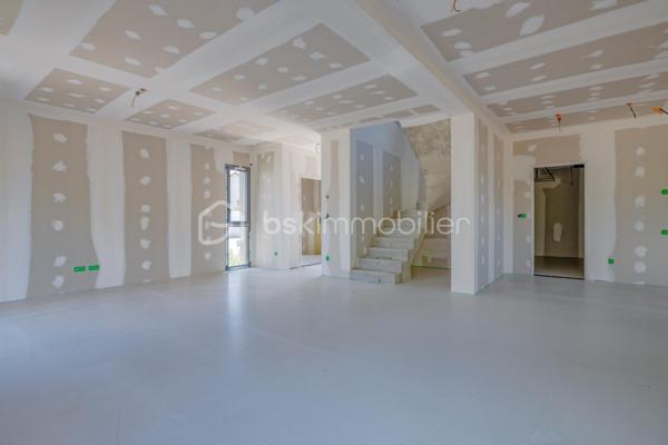 Découvrez cette magnifique maison mitoyenne contemporaine, idéalement située dans une impasse, dans un environnement résidentiel calme et recherché.

Actuellement en cours d'achèvement, cette maison offre une opportunité rare d'emménager dès cet automne dans un bien neuf aux prestations haut de gamme.

Répartie sur un rez-de-chaussée et un étage, elle propose 123 m² habitables, conçus pour offrir un cadre de vie aussi élégant que fonctionnel. Son agencement, imaginé par un architecte d'intérieur, met l'accent sur la luminosité, les volumes et le confort au quotidien.
Vous découvrirez une grande pièce de vie aux lignes arrondies, véritable signature architecturale de la maison. Cet espace lumineux offre de nombreuses possibilités d'aménagement et permet de créer un intérieur unique.

La maison comprend 3 chambres, dont une belle suite parentale avec dressing et salle d'eau privative, et un espace bureau. Les grandes baies vitrées et la hauteur sous plafond supérieure à 2,70 m renforcent la sensation d'espace et baignent les pièces de lumière naturelle.
Implantée sur un terrain avec entrée privative, elle dispose également d'un garage, d'une terrasse ainsi que d'un balcon à l'étage. Les extérieurs, sans vis-à-vis, offrent un cadre de vie intime et agréable.

Les prestations ont été soigneusement sélectionnées pour répondre aux attentes, la maison sera livrée avec :
Carrelage grand format 120 × 120 cm.
Chauffage au sol.
Climatisation réversible.
Grandes baies vitrées.
Finitions haut de gamme.
Matériaux de qualité.

Vous aurez également la possibilité de personnaliser votre cuisine, afin de créer un intérieur entièrement à votre image.

Une maison contemporaine aux prestations premium, alliant design, confort et qualité de construction, idéale pour celles et ceux qui recherchent un bien neuf dans un environnement paisible.

Contactez-nous dès aujourd'hui pour obtenir davantage d'informations et découvrir cette future maison.