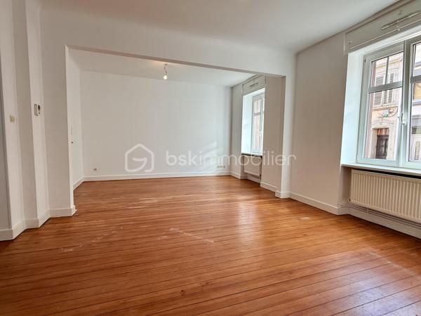 À seulement 300 mètres du centre-ville de Sarreguemines, découvrez cet appartement de plus de 83 m², situé au rez-de-chaussée d’une petite copropriété, dans une rue calme et peu passante.

L’appartement se distingue par ses beaux volumes et sa luminosité, avec notamment un agréable salon-séjour-cuisine offrant un espace de vie très confortable.

Les deux chambres, situées à l’arrière de l’appartement, bénéficient d’un environnement calme et donnent sur la cour. L’une d’elles dispose d’un accès direct et privatif à la salle de bains, équipée à la fois d’une douche et d’une baignoire.

L’ensemble de l’appartement vient d’être entièrement repeint. Il conserve également le charme d’un ancien parquet massif, qui mériterait d’être rénové, décapé et éventuellement revitrifié afin de retrouver tout son cachet.

La copropriété est de petite taille et bénéficie d’un syndic bénévole. L’immeuble est en bon état et les parties communes sont particulièrement bien entretenues.

Autre véritable atout : l’appartement est vendu avec deux garages, accessibles par un porche, et une grande cave. L’un des deux garages est actuellement loué, offrant ainsi un revenu locatif complémentaire à son propriétaire.