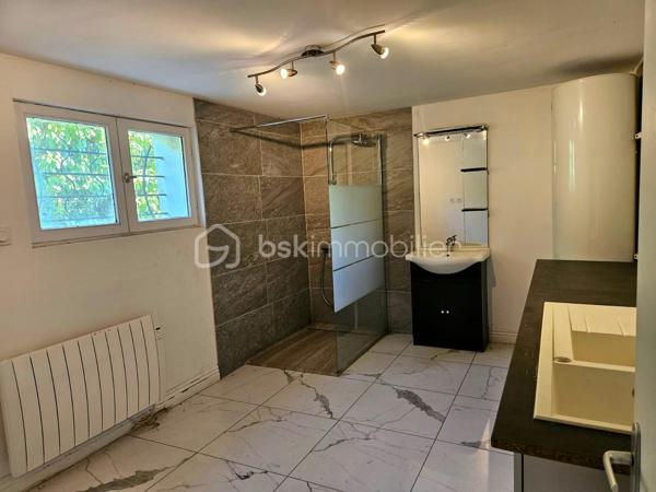 BOURGES – Située à moins de 5 minutes à pied de l'UNIVERSITÉ, découvrez une MAISON aux MULTIPLES POSSIBILITÉS !

Sur une magnifique PARCELLE de 1 024 m², laissez-vous séduire par cette maison de 177 m² habitables, offrant de BEAUX VOLUMES et un POTENTIEL qui ne demande qu'à être révélé.

Dès l'entrée, vous découvrirez une agréable PIÈCE DE VIE d'environ 30 m² comprenant l'entrée, le salon / séjour, réchauffée par une CHEMINÉE INSERT dont la chaleur est intelligemment répartie dans plusieurs pièces de la maison grâce à un système de GAINES DE DISTRIBUTION.

Dans son prolongement, une CUISINE AMÉNAGÉE ET ÉQUIPÉE d'environ 13 m² vous attend avec sa plaque de cuisson gaz, sa hotte, son four et son lave-vaisselle.

Ce niveau accueille également un BUREAU de 8 m², idéal pour le télétravail, ainsi que TROIS CHAMBRES d'environ 11 m², 10 m² et 9 m², une SALLE DE BAINS et un WC INDÉPENDANT.

À l'étage, un vaste DÉGAGEMENT d'environ 15 m² dessert DEUX CHAMBRES supplémentaires d'environ 9 m² chacune, une SALLE D'EAU avec WC ainsi qu'un GRENIER.

Le SOUS-SOL COMPLET constitue un véritable atout. Vous y trouverez un GRAND GARAGE de 52 m², une BUANDERIE avec SALLE D'EAU d'environ 11,5 m², un WC INDÉPENDANT ainsi qu'un STUDIO d'environ 28 m², équipé de son coin cuisine et bénéficiant de son PROPRE ACCÈS EXTÉRIEUR.

Véritable VALEUR AJOUTÉE de cette propriété, ce STUDIO avec ACCÈS INDÉPENDANT bénéficie également d'un petit SAS D'ACCUEIL, un véritable atout pour l'exercice d'une ACTIVITÉ PROFESSIONNELLE en permettant de recevoir la clientèle dans un espace dédié. Il pourra également accueillir votre FAMILLE ou vos AMIS tout en leur offrant leur propre INTIMITÉ et une réelle AUTONOMIE, ou encore être aménagé en LOGEMENT LOCATIF afin de répondre à la forte DEMANDE ÉTUDIANTE grâce à la proximité immédiate de l'UNIVERSITÉ de Bourges.

À l'extérieur, le charme opère immédiatement.
Le terrain, entièrement CLOS et ARBORÉ, offre de nombreux espaces de stationnement, un SECOND GARAGE d'environ 14 m² et un ABRI attenant à la maison de 14 m². Il est également traversé, en fond de parcelle, par le LANGIS, petit cours d'eau participant à l'alimentation des emblématiques MARAIS DE BOURGES. Une présence discrète qui confère à cette propriété une atmosphère paisible, bucolique... et un véritable supplément d'âme.

Côté CONFORT, la maison dispose de MENUISERIES PVC DOUBLE VITRAGE, de VOLETS ROULANTS ÉLECTRIQUES, y compris sur les VELUX, d'un chauffage assuré par la CHEMINÉE INSERT complétée par des RADIATEURS ÉLECTRIQUES. 
Raccordée au TOUT-À-L'ÉGOUT, la maison bénéficie également de la FIBRE OPTIQUE.

Quelques travaux de rafraîchissement et d'amélioration énergétique permettront de révéler tout le potentiel de cette propriété.

Que vous soyez à la recherche d'une MAISON FAMILIALE, d'un bien permettant d'allier HABITATION ET ACTIVITÉ PROFESSIONNELLE, ou encore d'un INVESTISSEMENT LOCATIF à proximité de l'université, cette maison saura répondre à vos attentes.

Au-delà des mètres carrés et des caractéristiques techniques, c'est son POTENTIEL qui marque les esprits. Une maison qui invite immédiatement à imaginer tout ce qu'elle peut devenir. Il ne vous reste plus qu'à venir la découvrir et à laisser, vous aussi, libre cours à votre imagination.