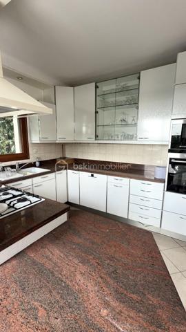 À Saint-Leu-la-Forêt (Val-d'Oise, 95), au calme et idéalement située, cette grande maison très lumineuse de 167 m² développe sept pièces dont quatre chambres. Très grand salon, grande cuisine, deux salles de bain, sous-sol total pouvant faire office de garage, terrasse et terrain arboré sans vis-à-vis composent un ensemble familial spacieux, accessible par une allée carrossable depuis le portail.

ACCÈS

Depuis le portail, une grande allée carrossable mène jusqu'à la maison. Cette configuration place l'habitation en retrait de la rue, ce qui renforce le calme et l'intimité du lieu, tout en facilitant l'accès en voiture jusqu'à la maison et le stationnement sur la propriété.

REZ-DE-CHAUSSÉE

Le très grand salon constitue le cœur de la maison. Il bénéficie d'une belle luminosité et offre un volume adapté aussi bien à la vie de famille qu'à la réception. La grande cuisine complète cet espace de vie, avec la surface nécessaire pour cuisiner confortablement et partager les repas du quotidien. Ce niveau accueille également une chambre, permettant une organisation de plain-pied pour des parents, des invités ou un usage sur le long terme, ainsi qu'une salle de bain et un WC séparé.

À L'ÉTAGE

L'étage dessert trois chambres, une salle de bain et un WC séparé. L'espace nuit est ainsi clairement séparé des pièces de vie, avec des sanitaires complets à chaque niveau, une organisation particulièrement pratique pour une famille avec enfants.

SOUS-SOL TOTAL

Le sous-sol total s'étend sur l'ensemble de l'emprise de la maison et peut faire office de garage. Il apporte un volume important en complément des 167 m² habitables, utilisable également en rangement, atelier ou buanderie selon les besoins du foyer.

EXTÉRIEUR

La maison bénéficie d'un beau terrain sans vis-à-vis, garantissant une vraie intimité dans l'usage quotidien de l'extérieur. Devant la maison, une grande parcelle arborée apporte un cadre verdoyant et participe à la tranquillité des lieux. Une terrasse prolonge l'habitation et permet de profiter des beaux jours, pour les repas comme pour la détente.

ENVIRONNEMENT ET ACCÈS

Saint-Leu-la-Forêt, commune du Val-d'Oise située en lisière de la forêt de Montmorency, offre un cadre résidentiel et verdoyant tout en restant reliée à Paris. La commune dispose de commerces, d'établissements scolaires et d'une gare sur la ligne H du Transilien. La maison bénéficie d'un emplacement calme au sein de la commune, un équilibre recherché entre tranquillité et accès aux services.

POINTS À NOTER

Ce bien s'adresse aux familles recherchant une grande maison lumineuse de 167 m², avec quatre chambres dont une de plain-pied, deux salles de bain, un sous-sol total et un extérieur arboré sans vis-à-vis, dans un secteur calme et recherché du Val-d'Oise.

Une grande maison lumineuse de 167 m², avec quatre chambres, sous-sol total et terrain arboré, au calme à Saint-Leu-la-Forêt.