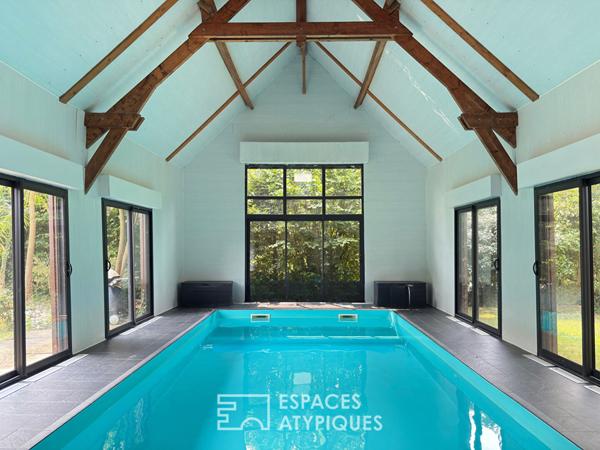 Villa contemporaine avec piscine intérieure dans un écrin de verdure.