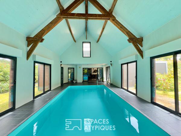 Villa contemporaine avec piscine intérieure dans un écrin de verdure.