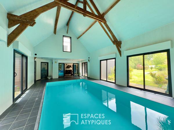 Villa contemporaine avec piscine intérieure dans un écrin de verdure.