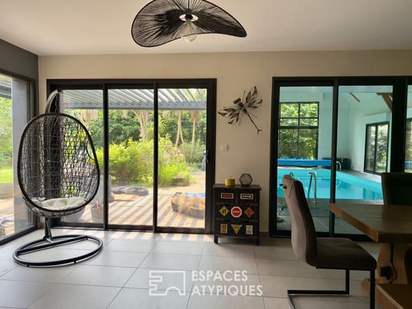 Villa contemporaine avec piscine intérieure dans un écrin de verdure.