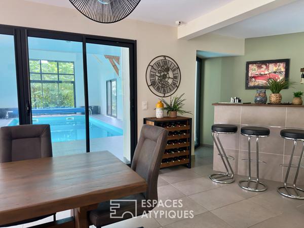 Villa contemporaine avec piscine intérieure dans un écrin de verdure.