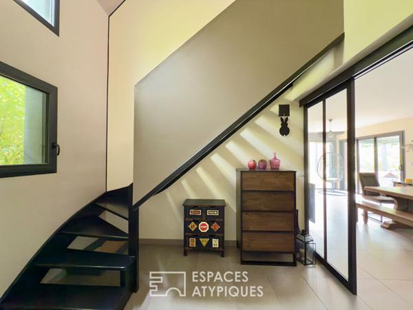 Villa contemporaine avec piscine intérieure dans un écrin de verdure.