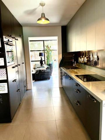 Située sur les hauteurs de Frontignan, cette maison R+1 de type T5, entièrement rénovée, développe 116 m² habitables sur une parcelle de 311 m². Elle se distingue par son caractère atypique et son ambiance chaleureuse et cosy.
Elle se compose au rez de chaussée d’un séjour avec cuisine de 38,56 m² et d'une salon véranda de 23 m2 offrant un très bel espace de vie, ainsi qu'un espace aménagé en coin nuit et un WC.
A l'étage, ce bien offre trois chambres, une salle d'eau et un WC. 
La climatisation réversible assure un confort appréciable tout au long de l’année. Le bien est aussi équipé d'un poele à bois.
À l’extérieur, vous bénéficierez d’un jardin avec piscine, d’une terrasse de 20 m² pour profiter pleinement des beaux jours.
Autre plus présence d'un garage de 9 m2 et d'une buanderie.