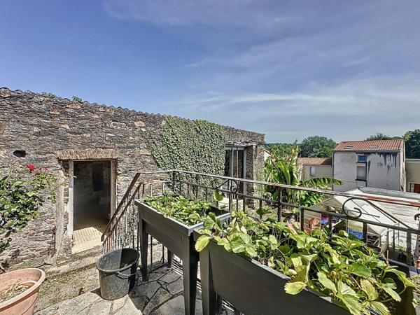 Maison de ville en pierre à vendre à OUDON dans le bourg proche commerces à pied avec 3 chambres cour et dépendances.