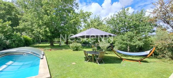 Maison en pierre à Lardy bourg avec un préau, une piscine sur 2095 m2 de terrain clos et arboré.