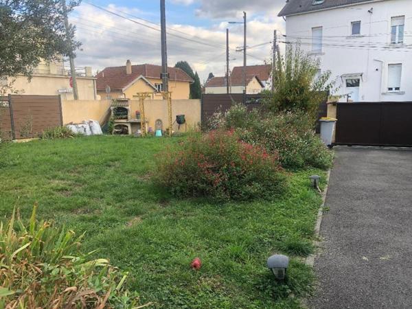 Maison de ville traditionnelle avec 4 chambres et un grand garage.