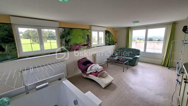 Rare sur le marché, cette propriété offre un ensemble immobilier complet alliant confort de vie, activité professionnelle et importantes capacités de stockage.
La maison principale développe environ 200 m² habitables et séduit par ses volumes généreux. Dès l'entrée, vous découvrirez un vaste hall agrémenté d'un espace bar. La pièce de vie de près de 60 m² comprend une cuisine aménagée et équipée ouverte sur la salle à manger et le salon. Une buanderie complète ce niveau.
L'espace nuit propose 5 belles chambres, dont une au rez-de-chaussée. À l'étage, une superbe chambre de 27 m² équipée d'un espace balnéo bénéficie d'un accès direct à une terrasse panoramique de 50 m² offrant une vue imprenable sur les environs.
Une salle de bains complète ainsi que des WC à chaque niveau.
Le sous-sol comprend un grand garage, une chaufferie et une seconde buanderie.

Un pôle professionnel aux multiples possibilités
Une vaste dépendance à usage professionnel 
Au rez-de-chaussée :
Garages, ateliers, espaces de stockage, pièce de vie, cave à vins.
À l'étage :
Bureaux, salle de réunion, local archives, sanitaires et WC.
Dans son prolongement, un important espace d'entreposage permet de répondre à de nombreux besoins professionnels ou logistiques.
Attenant à la dépendance, un appentis couvert d'environ 260 m²  

Les atouts de la propriété
- Maison principale de 200 m² habitables
- Grande pièce de vie de 60 m²
- 5 chambres dont une de plain-pied
- Suite de 27 m² avec espace balnéo
- Terrasse panoramique de 50 m²
- Sous-sol complet avec garage

Fort potentiel professionnel, artisanal ou de stockage
Ensemble immobilier rare offrant de multiples possibilités d'exploitation