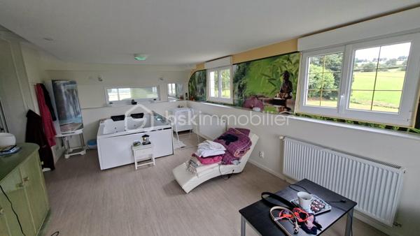 Rare sur le marché, cette propriété offre un ensemble immobilier complet alliant confort de vie, activité professionnelle et importantes capacités de stockage.
La maison principale développe environ 200 m² habitables et séduit par ses volumes généreux. Dès l'entrée, vous découvrirez un vaste hall agrémenté d'un espace bar. La pièce de vie de près de 60 m² comprend une cuisine aménagée et équipée ouverte sur la salle à manger et le salon. Une buanderie complète ce niveau.
L'espace nuit propose 5 belles chambres, dont une au rez-de-chaussée. À l'étage, une superbe chambre de 27 m² équipée d'un espace balnéo bénéficie d'un accès direct à une terrasse panoramique de 50 m² offrant une vue imprenable sur les environs.
Une salle de bains complète ainsi que des WC à chaque niveau.
Le sous-sol comprend un grand garage, une chaufferie et une seconde buanderie.

Un pôle professionnel aux multiples possibilités
Une vaste dépendance à usage professionnel 
Au rez-de-chaussée :
Garages, ateliers, espaces de stockage, pièce de vie, cave à vins.
À l'étage :
Bureaux, salle de réunion, local archives, sanitaires et WC.
Dans son prolongement, un important espace d'entreposage permet de répondre à de nombreux besoins professionnels ou logistiques.
Attenant à la dépendance, un appentis couvert d'environ 260 m²  

Les atouts de la propriété
- Maison principale de 200 m² habitables
- Grande pièce de vie de 60 m²
- 5 chambres dont une de plain-pied
- Suite de 27 m² avec espace balnéo
- Terrasse panoramique de 50 m²
- Sous-sol complet avec garage

Fort potentiel professionnel, artisanal ou de stockage
Ensemble immobilier rare offrant de multiples possibilités d'exploitation