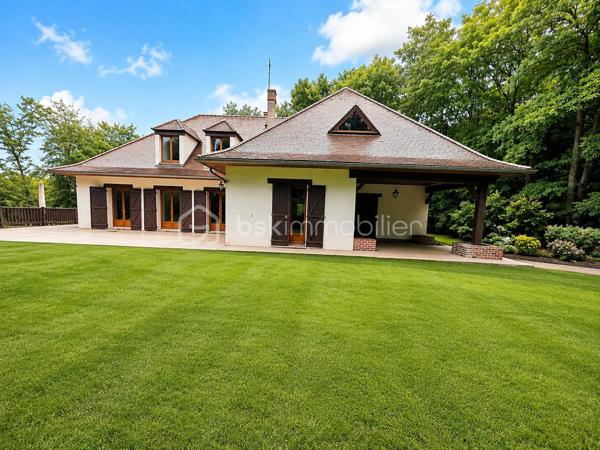 Demeure de charme de 12 pièces d’environ 344 m² habitables sur sous-sol total de 241 m²– Grand terrain boisé DE 7 300 m², calme absolu, sans vis-à-vis, 9 chambres, deux salles d'eau, une salle de bain, quatre WC séparés, avec près de 585 m² de potentiel global entre habitation et dépendances.

Au cœur d’un environnement rare, paisible et verdoyant, venez découvrir cette superbe propriété de charme, nichée dans un écrin de nature d’environ 7 300 m². Ici, tout invite à la sérénité : le calme, les arbres, l’espace, l’absence de vis-à-vis et cette impression immédiate d’être dans un lieu privilégié, à l’abri du bruit et du regard.

Dès l’arrivée, la maison séduit par son allure élégante, son architecture chaleureuse et ses très beaux volumes. Avec environ 344 m² habitables, elle offre un confort de vie remarquable, pensé pour une grande famille, pour recevoir, pour télétravailler, ou encore pour imaginer un projet de résidence secondaire, familiale ou de maison d’hôtes.

Le rez-de-chaussée développe à lui seul près de 200 m² et s’articule autour d’une pièce de vie spectaculaire d’environ 170 m². Ce vaste espace, à la fois lumineux, convivial et impressionnant par ses volumes, constitue le véritable cœur de la maison. Le hall et la pièce de réception créent immédiatement une atmosphère unique : on s’y projette naturellement pour partager de grands repas, recevoir des amis, profiter de moments en famille ou simplement savourer le calme de la propriété.

La maison dispose également d’une cuisine fonctionnelle, de plusieurs chambres au rez-de-chaussée, de salles d’eau, de rangements et d’espaces de dégagement généreux. Les ouvertures sur l’extérieur permettent de profiter pleinement du jardin, des terrasses et de la nature environnante.

À l’étage, l’espace continue de surprendre par ses volumes. Environ 145 m² habitables viennent compléter la maison, avec une grande pièce salon-bibliothèque d’environ 48 m², idéale pour créer un second salon, une salle de jeux, un espace lecture, un bureau de caractère ou un lieu de détente indépendant. Plusieurs chambres supplémentaires permettent d’accueillir famille, enfants, invités ou d’aménager des espaces selon les besoins de chacun.

Cette propriété offre une vraie liberté d’usage : chacun peut y trouver sa place, sans jamais se sentir à l’étroit. Les volumes sont rares, l’organisation est fluide, et la maison dégage une atmosphère à la fois familiale, élégante et chaleureuse.

Côté annexes, le bien dispose d’un sous-sol d’environ 187 m², offrant de nombreuses possibilités : garage, stockage, atelier, cave, espace technique ou rangement complémentaire. Un grand préau d’environ 54 m² permet également de stationner plusieurs véhicules à l’abri, avec une capacité confortable de deux à quatre voitures selon l’organisation souhaitée. Au total, les dépendances représentent environ 241 m², portant l’ensemble habitable et annexes à environ 585 m².

À l’extérieur, le terrain boisé d’environ 7 300 m² constitue l’un des grands atouts de cette propriété. Le cadre est superbe, verdoyant, intime, sans vis-à-vis, avec une vraie sensation d’espace et de tranquillité. C’est un lieu où l’on respire, où l’on entend la nature, où l’on peut imaginer des moments simples et précieux : petits-déjeuners en terrasse, soirées d’été, jeux d’enfants, promenades dans le jardin, ou simplement le plaisir de profiter d’un environnement exceptionnel au quotidien.

Cette demeure s’adresse à des acquéreurs en recherche d’un bien différent, avec une âme, de l’espace, du charme et un cadre de vie privilégié. Une maison qui ne se résume pas à des mètres carrés, mais à une véritable sensation de bien-être dès les premiers instants.

Un bien rare, généreux, lumineux, fonctionnel et plein de potentiel, à découvrir absolument pour en apprécier toute la force et l’atmosphère.

Pour tout renseignement complémentaire ou pour organiser une visite, je reste à votre disposition. Une visite permettra de ressentir pleinement le charme, le calme et le caractère exceptionnel de cette propriété