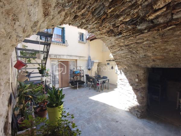 À l'entrée du village pittoresque de Faugères, au cœur d'un environnement réputé pour son vignoble AOP et sa qualité de vie, découvrez cette authentique maison en pierre de 179 m² habitables, organisée autour d'un agréable patio intérieur.
La propriété offre une configuration rare avec deux espaces de vie communicants : une habitation principale pleine de charme et une suite indépendante avec espace bien-être, idéale pour accueillir famille, amis, exercer une activité touristique ou créer un espace dédié au télétravail ou à une profession libérale.

L'habitation principale
L'entrée s'ouvre sur une spacieuse cuisine de 23 m², équipée d'une climatisation réversible et d'un poêle à granulés.
Elle mène à un superbe salon de 36 m², aménagé dans une ancienne écurie. Son plafond voûté, sa belle hauteur sous plafond et sa grande baie vitrée ouverte sur le patio lui confèrent un caractère unique.
Un WC indépendant complète le rez-de-chaussée, ainsi qu'un accès direct au garage de 35 m² équipé d'une porte motorisée.
À l'étage, une première chambre de 20,5 m² avec dressing (actuellement aménagée en bureau) précède une agréable suite parentale de 23,8 m² avec salle d'eau, double vasque, WC indépendant et climatisation.

La suite indépendante bien-être
Communicante avec la maison tout en bénéficiant d'un accès par le patio, cette seconde partie de la propriété comprend :
un salon / salle à manger de 33,65 m² avec climatisation et poêle à granulés ;
un WC indépendant ;
une vaste suite d'environ 40 m² avec salle d'eau ;
un jacuzzi privatif ;
un sauna dans une pièce attenante ;
une terrasse privée de 8 m².

Cet espace peut accueillir une activité de location saisonnière, recevoir famille et amis en toute autonomie ou encore être intégré à l'habitation principale.

Un extérieur intimiste
Véritable cœur de la maison, le patio de 31 m², à l'abri des regards, est accessible depuis les deux espaces de vie, le garage et la rue située à l'arrière de la propriété.
Il dispose d'une cuisine d'été de 5,6 m² ainsi que d'une buanderie de 5 m², parfaites pour profiter pleinement des beaux jours.

Les atouts
179 m² habitables
Deux espaces de vie communicants
Suite indépendante avec jacuzzi et sauna
Ancienne écurie rénovée avec salon voûté
Patio de 31 m²
Garage de 35 m²
Cuisine d'été
Climatisations réversibles
Deux poêles à granulés
Fibre optique
Faible taxe foncière 

Faugères offre un cadre de vie recherché entre vignobles et nature, avec école, commerces de proximité, restaurants et domaines viticoles. Béziers, Pézenas, les plages méditerranéennes et le Parc naturel régional du Haut-Languedoc sont rapidement accessibles.

Prix : 290 000 € HAI