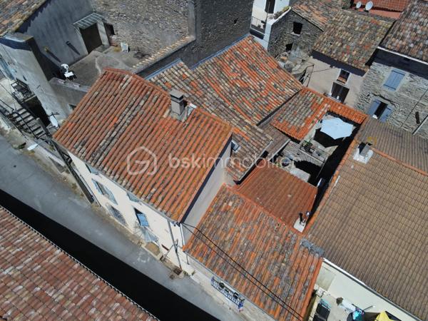 À l'entrée du village pittoresque de Faugères, au cœur d'un environnement réputé pour son vignoble AOP et sa qualité de vie, découvrez cette authentique maison en pierre de 179 m² habitables, organisée autour d'un agréable patio intérieur.
La propriété offre une configuration rare avec deux espaces de vie communicants : une habitation principale pleine de charme et une suite indépendante avec espace bien-être, idéale pour accueillir famille, amis, exercer une activité touristique ou créer un espace dédié au télétravail ou à une profession libérale.

L'habitation principale
L'entrée s'ouvre sur une spacieuse cuisine de 23 m², équipée d'une climatisation réversible et d'un poêle à granulés.
Elle mène à un superbe salon de 36 m², aménagé dans une ancienne écurie. Son plafond voûté, sa belle hauteur sous plafond et sa grande baie vitrée ouverte sur le patio lui confèrent un caractère unique.
Un WC indépendant complète le rez-de-chaussée, ainsi qu'un accès direct au garage de 35 m² équipé d'une porte motorisée.
À l'étage, une première chambre de 20,5 m² avec dressing (actuellement aménagée en bureau) précède une agréable suite parentale de 23,8 m² avec salle d'eau, double vasque, WC indépendant et climatisation.

La suite indépendante bien-être
Communicante avec la maison tout en bénéficiant d'un accès par le patio, cette seconde partie de la propriété comprend :
un salon / salle à manger de 33,65 m² avec climatisation et poêle à granulés ;
un WC indépendant ;
une vaste suite d'environ 40 m² avec salle d'eau ;
un jacuzzi privatif ;
un sauna dans une pièce attenante ;
une terrasse privée de 8 m².

Cet espace peut accueillir une activité de location saisonnière, recevoir famille et amis en toute autonomie ou encore être intégré à l'habitation principale.

Un extérieur intimiste
Véritable cœur de la maison, le patio de 31 m², à l'abri des regards, est accessible depuis les deux espaces de vie, le garage et la rue située à l'arrière de la propriété.
Il dispose d'une cuisine d'été de 5,6 m² ainsi que d'une buanderie de 5 m², parfaites pour profiter pleinement des beaux jours.

Les atouts
179 m² habitables
Deux espaces de vie communicants
Suite indépendante avec jacuzzi et sauna
Ancienne écurie rénovée avec salon voûté
Patio de 31 m²
Garage de 35 m²
Cuisine d'été
Climatisations réversibles
Deux poêles à granulés
Fibre optique
Faible taxe foncière 

Faugères offre un cadre de vie recherché entre vignobles et nature, avec école, commerces de proximité, restaurants et domaines viticoles. Béziers, Pézenas, les plages méditerranéennes et le Parc naturel régional du Haut-Languedoc sont rapidement accessibles.

Prix : 290 000 € HAI