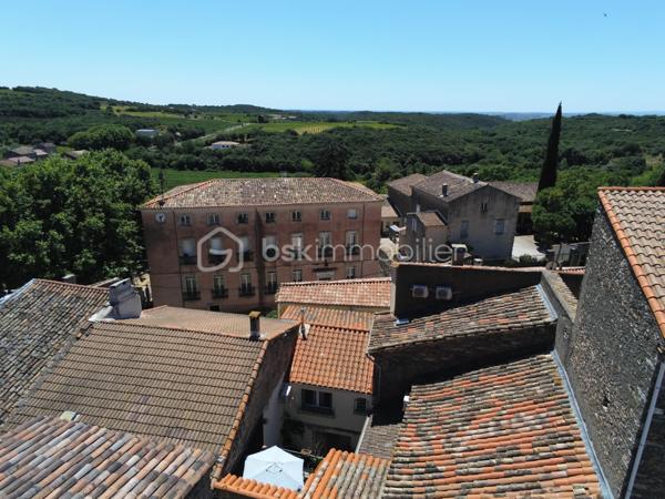 À l'entrée du village pittoresque de Faugères, au cœur d'un environnement réputé pour son vignoble AOP et sa qualité de vie, découvrez cette authentique maison en pierre de 179 m² habitables, organisée autour d'un agréable patio intérieur.
La propriété offre une configuration rare avec deux espaces de vie communicants : une habitation principale pleine de charme et une suite indépendante avec espace bien-être, idéale pour accueillir famille, amis, exercer une activité touristique ou créer un espace dédié au télétravail ou à une profession libérale.

L'habitation principale
L'entrée s'ouvre sur une spacieuse cuisine de 23 m², équipée d'une climatisation réversible et d'un poêle à granulés.
Elle mène à un superbe salon de 36 m², aménagé dans une ancienne écurie. Son plafond voûté, sa belle hauteur sous plafond et sa grande baie vitrée ouverte sur le patio lui confèrent un caractère unique.
Un WC indépendant complète le rez-de-chaussée, ainsi qu'un accès direct au garage de 35 m² équipé d'une porte motorisée.
À l'étage, une première chambre de 20,5 m² avec dressing (actuellement aménagée en bureau) précède une agréable suite parentale de 23,8 m² avec salle d'eau, double vasque, WC indépendant et climatisation.

La suite indépendante bien-être
Communicante avec la maison tout en bénéficiant d'un accès par le patio, cette seconde partie de la propriété comprend :
un salon / salle à manger de 33,65 m² avec climatisation et poêle à granulés ;
un WC indépendant ;
une vaste suite d'environ 40 m² avec salle d'eau ;
un jacuzzi privatif ;
un sauna dans une pièce attenante ;
une terrasse privée de 8 m².

Cet espace peut accueillir une activité de location saisonnière, recevoir famille et amis en toute autonomie ou encore être intégré à l'habitation principale.

Un extérieur intimiste
Véritable cœur de la maison, le patio de 31 m², à l'abri des regards, est accessible depuis les deux espaces de vie, le garage et la rue située à l'arrière de la propriété.
Il dispose d'une cuisine d'été de 5,6 m² ainsi que d'une buanderie de 5 m², parfaites pour profiter pleinement des beaux jours.

Les atouts
179 m² habitables
Deux espaces de vie communicants
Suite indépendante avec jacuzzi et sauna
Ancienne écurie rénovée avec salon voûté
Patio de 31 m²
Garage de 35 m²
Cuisine d'été
Climatisations réversibles
Deux poêles à granulés
Fibre optique
Faible taxe foncière 

Faugères offre un cadre de vie recherché entre vignobles et nature, avec école, commerces de proximité, restaurants et domaines viticoles. Béziers, Pézenas, les plages méditerranéennes et le Parc naturel régional du Haut-Languedoc sont rapidement accessibles.

Prix : 290 000 € HAI