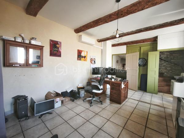 À l'entrée du village pittoresque de Faugères, au cœur d'un environnement réputé pour son vignoble AOP et sa qualité de vie, découvrez cette authentique maison en pierre de 179 m² habitables, organisée autour d'un agréable patio intérieur.
La propriété offre une configuration rare avec deux espaces de vie communicants : une habitation principale pleine de charme et une suite indépendante avec espace bien-être, idéale pour accueillir famille, amis, exercer une activité touristique ou créer un espace dédié au télétravail ou à une profession libérale.

L'habitation principale
L'entrée s'ouvre sur une spacieuse cuisine de 23 m², équipée d'une climatisation réversible et d'un poêle à granulés.
Elle mène à un superbe salon de 36 m², aménagé dans une ancienne écurie. Son plafond voûté, sa belle hauteur sous plafond et sa grande baie vitrée ouverte sur le patio lui confèrent un caractère unique.
Un WC indépendant complète le rez-de-chaussée, ainsi qu'un accès direct au garage de 35 m² équipé d'une porte motorisée.
À l'étage, une première chambre de 20,5 m² avec dressing (actuellement aménagée en bureau) précède une agréable suite parentale de 23,8 m² avec salle d'eau, double vasque, WC indépendant et climatisation.

La suite indépendante bien-être
Communicante avec la maison tout en bénéficiant d'un accès par le patio, cette seconde partie de la propriété comprend :
un salon / salle à manger de 33,65 m² avec climatisation et poêle à granulés ;
un WC indépendant ;
une vaste suite d'environ 40 m² avec salle d'eau ;
un jacuzzi privatif ;
un sauna dans une pièce attenante ;
une terrasse privée de 8 m².

Cet espace peut accueillir une activité de location saisonnière, recevoir famille et amis en toute autonomie ou encore être intégré à l'habitation principale.

Un extérieur intimiste
Véritable cœur de la maison, le patio de 31 m², à l'abri des regards, est accessible depuis les deux espaces de vie, le garage et la rue située à l'arrière de la propriété.
Il dispose d'une cuisine d'été de 5,6 m² ainsi que d'une buanderie de 5 m², parfaites pour profiter pleinement des beaux jours.

Les atouts
179 m² habitables
Deux espaces de vie communicants
Suite indépendante avec jacuzzi et sauna
Ancienne écurie rénovée avec salon voûté
Patio de 31 m²
Garage de 35 m²
Cuisine d'été
Climatisations réversibles
Deux poêles à granulés
Fibre optique
Faible taxe foncière 

Faugères offre un cadre de vie recherché entre vignobles et nature, avec école, commerces de proximité, restaurants et domaines viticoles. Béziers, Pézenas, les plages méditerranéennes et le Parc naturel régional du Haut-Languedoc sont rapidement accessibles.

Prix : 290 000 € HAI