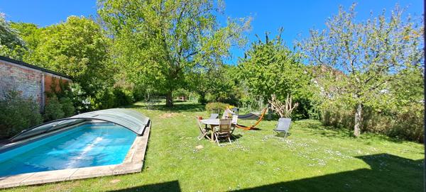 Ensemble immobilier à Lardy bourg comprenant une maison familiale en pierres de 130 m2, un préau, une piscine sur 2095 m2 de terrain arboré.