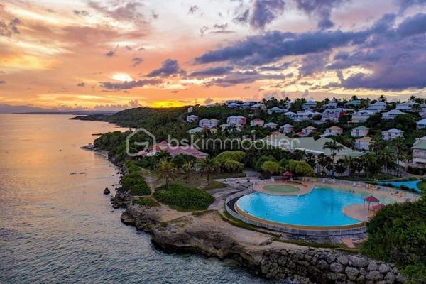 EXCLUSIVITE
Delphine MIRANDA pour BSK IMMOBILIER
Saint François - Anse des Rochers
Célèbre site doté d'une magnifique cocoteraie s'étendant sur 7 hectares , d'un accès plage direct , d'un restaurant de plage, d'une grande
piscine à débordement vue mer, d'un cours de tennis et d'un service de gardiennage avec accès sécurisé, le domaine de l' Anse des Rochers
est sans conteste le lieu par excellence voué à un investissement locatif saisonnier.
Je vous propose ce joli quart de villa d'une surface habitable d'environ 34 m2, bien placé en retrait au calme.
Il se compose d'une loggia avec cuisine équipée et coin salon avec fermetures par volets roulants et une jolie vue dégagée.
La pièce de vie climatisée possède de nombreux rangements et un dressing .
La salle d'eau avec douche à l'italienne a été rénové et possède un toilette indépendant.
Une citerne tampon sera installée dans les prochains jours pour votre confort.
Un investissement locatif , un pied à terre ou votre résidence principale tout s'y prête , il est vendu meublé clé en main (prévoir un
aménagement avec un lit pour le coin chambre), me consulter pour de plus amples informations.
Les charges de copropriété inclus l'eau , l'électricité, entretien des communs, piscine et jardin, service de gardiennage et le fond de roulement
du syndic.
Contacter moi pour échanger sur votre projet , merci de privilégier l'appel ou message par whatsapp.

DPE Guadeloupe réalisé en date du 26 Février 2026
Total Production déduite (ICE) : 61,46 kWhet/m2.an
Equivalent en énergie primaire : 215,10 kWhep/m2an
Emission de gaz à effet de serre : 49,17 kgCO2/m2an