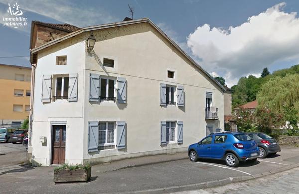 Une maison à usage d'habitation, mitoyenne ou contigüe avec d'autres maisons, comprenant: