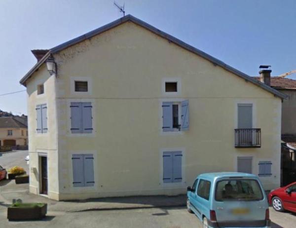 Une maison à usage d'habitation, mitoyenne ou contigüe avec d'autres maisons, comprenant: