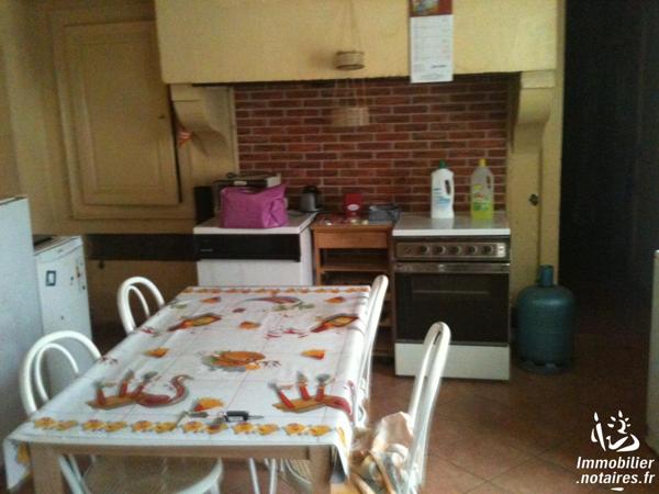 Une maison à usage d'habitation, mitoyenne ou contigüe avec d'autres maisons, comprenant: