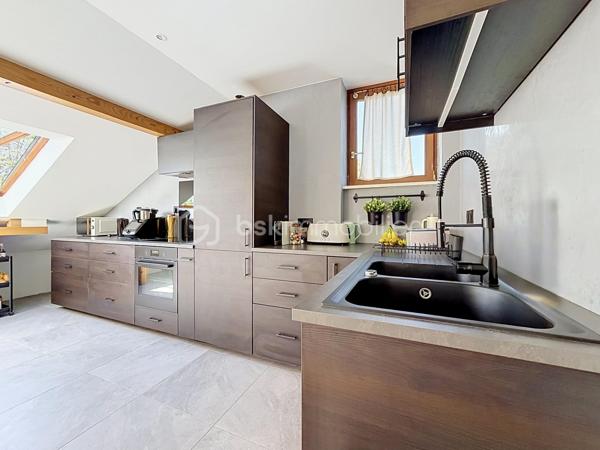 60 m² Carrez • 80 m² au sol • 2 chambres • 4ᵉ et dernier étage sans ascenseur • Triple exposition Est/Sud/Ouest • Cave • Stationnement libre dans la copropriété

Chaque bien possède son identité. Celui-ci séduira les amateurs de volumes, de lumière et de lieux de vie qui ont une âme.

A Didenheim, situation privilégiée, au fond d'une impasse, dans un environnement particulièrement calme. Situé au 4ᵉ et dernier étage d'une copropriété entretenue, cet appartement développe 60 m² Carrez et près de 80 m² au sol, offrant des volumes généreux et une atmosphère chaleureuse que l'on retrouve rarement dans cette gamme de biens.

Traversant et bénéficiant d'une triple exposition Est, Sud et Ouest, il profite d'une luminosité exceptionnelle tout au long de la journée. Les poutres apparentes, les volumes sous toiture et les nombreux Velux créent une ambiance unique, mêlant le charme des appartements sous les toits au confort d'une rénovation contemporaine.

La pièce de vie, ouverte sur une cuisine entièrement équipée, constitue un espace convivial où chaque détail a été pensé pour allier esthétique et fonctionnalité. Les nombreux rangements réalisés sur mesure sous les pentes optimisent parfaitement les volumes et participent au caractère soigné de l'ensemble. Les Velux sont équipés de volets roulants électriques solaires pour un confort optimal au quotidien.

Entièrement rénové en 2022, l'appartement ne nécessite aucun travaux. La cuisine et la salle d'eau ont été entièrement repensées avec des matériaux actuels et les parquets ont été rénovés, permettant aux futurs propriétaires de s'installer immédiatement.

L'espace nuit comprend deux chambres, dont l'une peut facilement accueillir un dressing ou un espace bureau selon vos besoins. La salle d'eau dispose d'une douche à l'italienne, d'un meuble vasque contemporain, d'un WC suspendu et d'un sèche-serviettes.

Le chauffage est individuel électrique. Une cave privative vient compléter ce bien.

La copropriété, appréciée pour son entretien régulier et son environnement verdoyant, met également à disposition de ses résidents un agréable jardin commun arboré. Le stationnement est particulièrement simple grâce aux nombreuses places de parking libres disponibles au sein de la résidence, un véritable confort au quotidien.

Brunstatt-Didenheim figure parmi les communes les plus recherchées de la première couronne mulhousienne. Appréciée pour sa qualité de vie, elle offre un environnement résidentiel verdoyant, à l'écart d'une urbanisation dense, tout en permettant de rejoindre rapidement Mulhouse, l'autoroute A36, la RN66 ainsi que les principaux bassins d'emploi. Les commerces, les établissements scolaires, les transports en commun, les équipements sportifs et les nombreux espaces de promenade contribuent au quotidien agréable qu'offre la commune.

Cet appartement conviendra parfaitement à un premier achat, à un couple ou à toute personne recherchant un bien lumineux, de caractère, sans travaux et prêt à accueillir un nouveau projet de vie.

Un appartement où l'on vient d'abord pour une visite… et dont on repart souvent avec l'envie de s'y installer.

Prix de vente : 135 000 € honoraires d'agence inclus.

Contacter Carole KLUPS immobilier
Réseaux sociaux Carole Klups immo