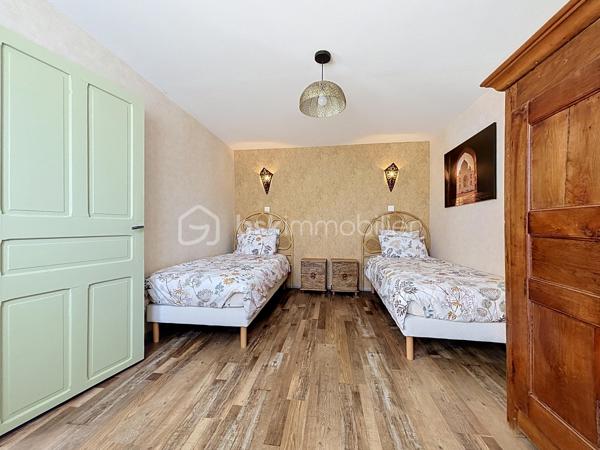 Situé à Bressuire, à seulement 5 minutes à pied de la Coulée Verte, cet ensemble immobilier entièrement rénové offre un cadre idéal pour une maison familiale ou un projet d’activité touristique.

La maison principale se compose d’une entrée donnant sur une agréable pièce de vie, comprenant une cuisine aménagée et équipée ouverte sur le salon, agrémenté d’un insert à bois. Celui-ci donne accès à une salle à manger installée sous une véranda, offrant une belle vue sur le jardin.

La partie nuit comprend quatre chambres, deux salles d’eau et des WC indépendants.

Un logement attenant, bénéficiant d’un accès indépendant, complète cette propriété. Il se compose d’une cuisine ouverte sur le séjour, d’une chambre, d’une salle d’eau avec WC et d’une buanderie. Cet espace peut notamment convenir à un hébergement touristique ou accueillir des proches.

La propriété dispose également de plusieurs dépendances en pierre, implantées sur un terrain paysagé et clôturé, agrémenté d’une piscine couverte.