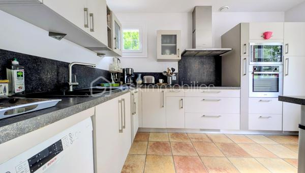 EXCLUSIVITE

Située sur la commune prisée de Douvres-la-Délivrande,  à proximité immédiate de commerces, cette belle propriété de 146 m² habitables allie le cachet de l'ancien au confort moderne. 
Elle se distingue dès l'extérieur par son architecture soignée, dotée d'une toiture en tuiles plates et d'une façade habillée de pierres de parement. 
Édifiée sur un magnifique jardin arboré de 900 m², elle offre de superbes volumes et un agencement idéal.

 Les Caractéristiques Clés

 * Surface habitable : 146 m²
 * Surface du terrain : 900 m²
 * Nombre de chambres : 5 (dont une au rez-de-chaussée)
 * Sous-sol total : 85 m²

 L'Agencement Intérieur
Au rez-de-chaussée (entièrement revêtu de tomettes authentiques et des poutres apparentes dans l'entrée) :
 * Une vaste pièce de vie de 38 m², chaleureuse et lumineuse grâce à sa triple exposition, agrémentée d'un poêle à pellets.
 * Une cuisine aménagée et parfaitement équipée.
 * Une chambre et une salle d'eau , permettant une vie de plain-pied confortable.

*À l'étage (desservi par un escalier et un palier conservant le charme des tomettes) :
 * Quatre belles chambres, dont une particulièrement spacieuse de plus de 20 m² habitables.
 * Une salle de bains indépendante équipée d'une baignoire.
 * Un WC séparé.

 Le Sous-Sol Complet (85 m²)
 * Un vaste garage d'environ 35 m².
 * Une très grande pièce de 40 m², offrant de multiples possibilités d'aménagement (atelier, salle de jeux, espace de stockage).

 Énergie et Fiscalité
 * Système de chauffage : Électrique couplé à un poêle à pellets pour un confort optimal.
 * Consommation énergétique réelle : Environ 2000 €/an d'électricité et 480 €/an de pellets (une consommation avérée largement inférieure aux estimations du DPE).
 * Taxe foncière : 2200 €

Vous n'avez plus qu'a mettre vos meubles et savourer le bonheur de vivre ici!