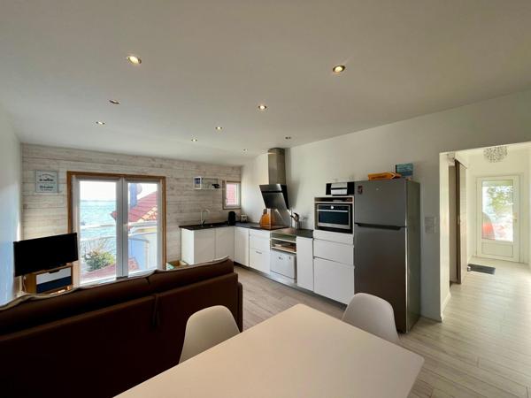 Appartement avec vue sur le bassin et accès direct plage + places de parking privatives.