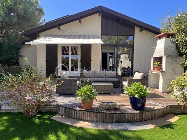 Laissez-vous charmer par cette pépite architecturale des années 80, édifiée au cœur d'un somptueux parc arboré et paysagé de près de 3 100 m², parsemé d'arbres fruitiers. Une véritable oasis de paix et de verdure, sans aucun vis-à-vis.
Dès le franchissement de la porte, cette propriété d'environ 180 m² habitables impose son style unique et ses volumes généreux. Le cœur de la maison s'articule autour d'une spectaculaire pièce de vie cathédrale sublimée par ses poutres apparentes et sa cheminée d'époque, insufflant une atmosphère à la fois chaleureuse et résolument authentique.


Côté intérieur : des prestations familiales et fonctionnelles

De plain-pied :
     Un vaste séjour cathédrale baigné de lumière avec cheminée.
     Une cuisine / des espaces de vie fluides complétés par 3 chambres confortables.
     Une salle de bains, un bureau (idéal télétravail), une buanderie et un garde-manger.
     Une agréable véranda, parfaite pour prolonger les soirées d'automne ou profiter des journées ensoleillées.

 À l’étage :
     Une élégante mezzanine en surplomb, offrant un espace lecture ou détente baigné de cachet.
     Une quatrième chambre supplémentaire et une salle d’eau privative.

Côté extérieur : un art de vivre privilégié

Le spectacle se poursuit dehors avec ce immense jardin arboré, véritable terrain de jeux ou havre de sérénité. Pour parfaire les beaux jours, une très grande piscine invite à la détente et aux moments de partage en famille ou entre amis.

Un garage double indépendant vient compléter les prestations de ce bien d'exception.
Les prestations techniques & Confort :
Surface habitable : 180 m2 Terrain : 3 100 m2 Divisible
 Chauffage : Électrique + climatisation réversible
Eau chaude : Ballon électrique
 Menuiseries : Double vitrage
 Stationnement : Garage double (2 places)

Une propriété rare sur le marché, alliance parfaite entre le charme de l'ancien revisité, l'architecture d'auteur et la quiétude de la nature.