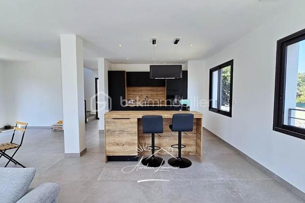À Poulx, situé a quelques minutes de Nîmes, cette maison contemporaine construite en 2024 se dévoile dans un environnement paisible, légèrement en hauteur, avec une vue dégagée qui donne immédiatement le ton. Dès l’extérieur, les lignes sont modernes, sobres et élégantes. La maison est non mitoyenne, parfaitement intégrée à son terrain d’environ 450 m², avec des aménagements pensés pour la tranquillité et la facilité d’entretien.

On accède à la maison par un cheminement soigné, où l’on perçoit tout de suite la qualité de la construction. Le stationnement est simple et confortable, avec plusieurs places de parking et un garage spacieux de 28 m², directement accessible depuis la maison.

À l’intérieur, la lumière est omniprésente. La pièce de vie offre de beaux volumes et une circulation fluide entre les espaces. Le séjour s’ouvre largement sur l’extérieur grâce à de grandes baies vitrées, laissant entrer la lumière naturelle tout au long de la journée et offrant une vue apaisante sur la végétation environnante. La cuisine, moderne et entièrement équipée, s’intègre parfaitement à l’ensemble, créant un lieu convivial où l’on imagine facilement les repas en famille ou entre amis.

Depuis la pièce de vie, la maison se prolonge naturellement vers l’extérieur. La coursive mène à une terrasse accueillante, au jardin et à la piscine, véritable cœur de la maison dès les beaux jours. Un espace pensé pour profiter pleinement du climat, se détendre, recevoir et vivre dehors autant que dedans.

À l’étage, l’ambiance devient plus intime. Trois chambres confortables composent l’espace nuit, accompagnées d’une salle de bain. La terrasse accessible depuis l’étage offre une vue dégagée sur les environs, un endroit idéal pour savourer un café le matin ou un moment de calme en fin de journée, face à un paysage ouvert et verdoyant.

Le niveau inférieur apporte une vraie modularité à la maison. Une chambre avec sa salle d’eau permet d’accueillir famille, amis ou de créer un espace indépendant, tout en conservant un accès direct au garage. Un agencement particulièrement pratique au quotidien.

Côté prestations, la maison répond aux standards actuels de confort et de performance. Climatisation réversible gainable, ballon thermodynamique, double vitrage, volets roulants électriques… Tout a été pensé pour offrir une maison économe, agréable à vivre et sans aucun travaux à prévoir.

Cette propriété s’adresse à ceux qui recherchent une maison neuve, contemporaine et lumineuse, avec des volumes généreux, des extérieurs soignés et une vraie qualité de vie, dans un secteur calme tout en restant proche de Nîmes.

Un bien où chaque espace a été pensé pour être vécu… et apprécié.

Pour plus d’informations ou organiser une visite, je suis disponible 24h/24 et 7j/7.
Contactez-moi directement au O6 20 75 00 O7.