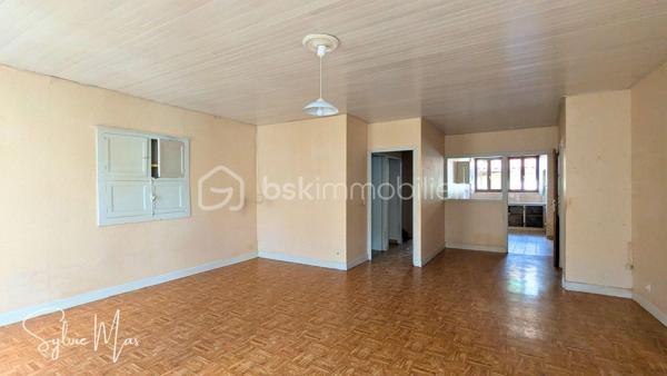 Au cœur du village, à proximité immédiate des commerces et services, cette maison offre environ 73 m² habitables, complétés par un espace chargé d’histoire : l’ancien atelier du forgeron, aujourd’hui utilisé comme garage. Avec ses 68 m², sa large porte et sa belle hauteur sous plafond, cet ancien atelier constitue un volume rare, idéal pour un artisan, un bricoleur, un artiste, un collectionneur ou simplement pour disposer d’un vaste espace de stockage.
L’habitation comprend : une entrée, un palier avec placard, une cuisine indépendante, un séjour lumineux, une chambre, une salle de bains, un WC indépendant ainsi qu'un grenier offrant un espace de stockage supplémentaire.
Grâce à sa double exposition Nord-Sud et à ses grandes ouvertures, la partie jour bénéficie d’une agréable lumière traversante.
Le garage est accessible depuis l'intérieur.